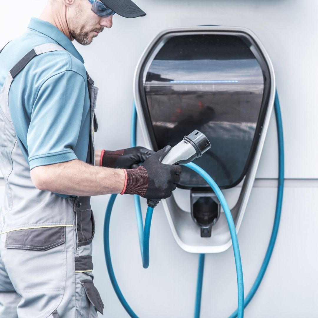 technician with EV charging station