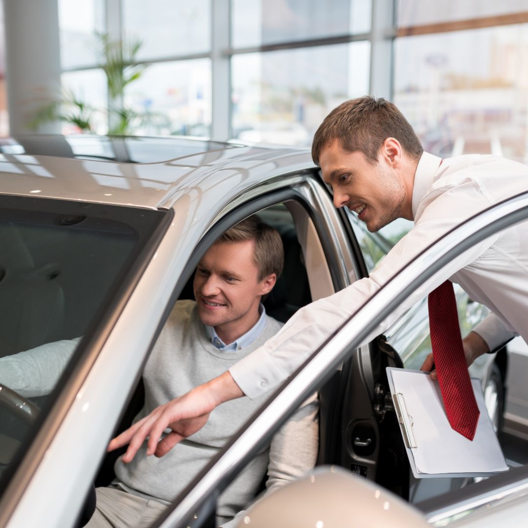 Car salesman showing features of a car to a customer