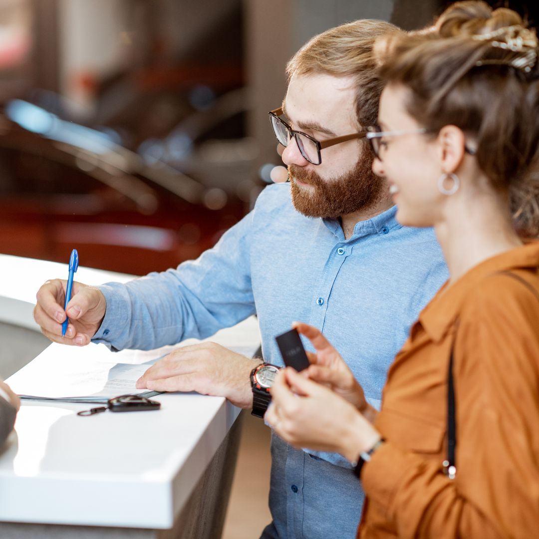 Couple signing a leasing deal at a dealership