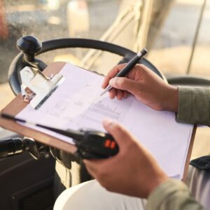 Holding a clipboard while sitting in a driver's seat