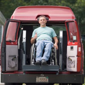A man in a wheelchair enters a van with an auto-lift