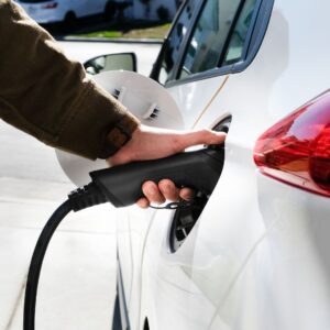 close up of hand charging electric car