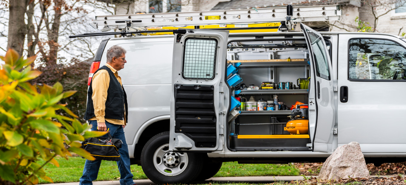 HVAC van for home services upfitted with a man walking toward it with a toolbox
