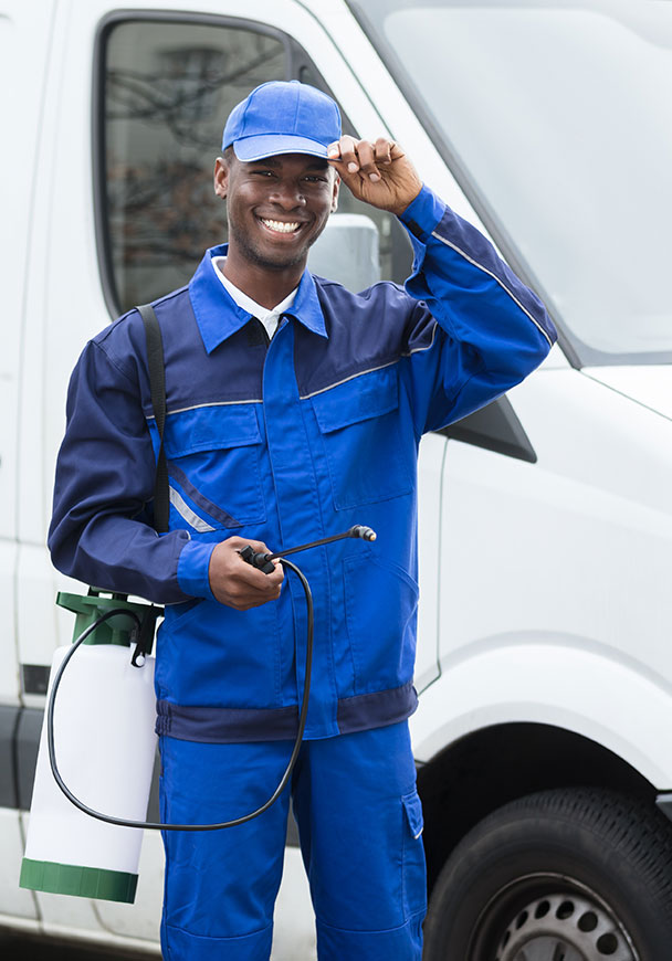 A man in a pest control uniform in front of a work truck