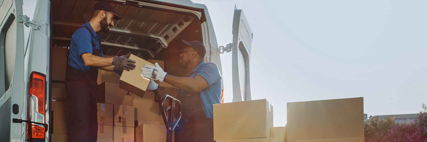 Two men loading packages onto a cargo van