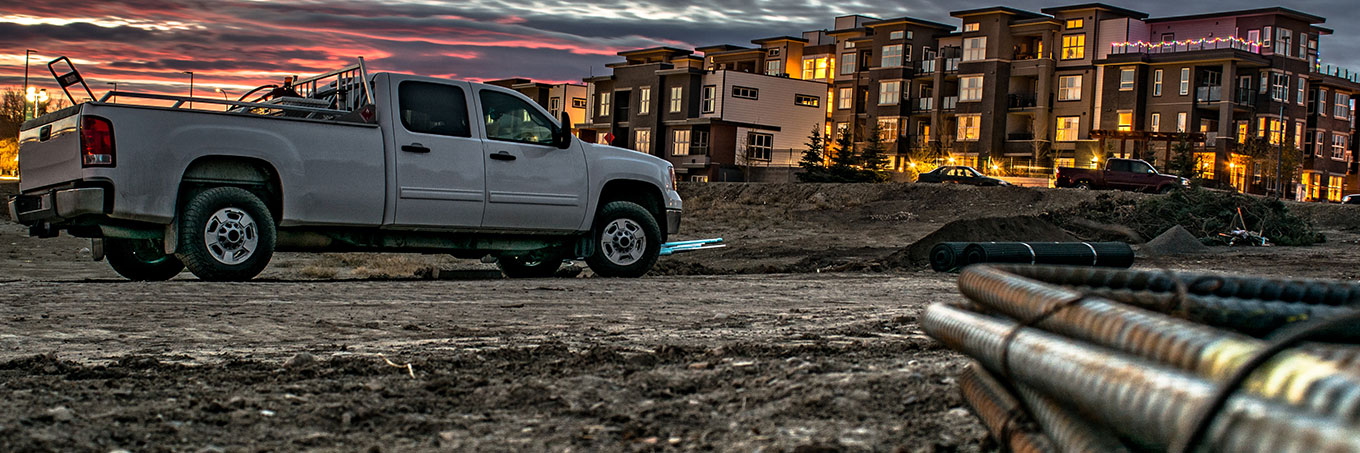 Truck with rebar in the foreground on a construction site at sunset