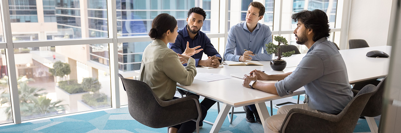 A group of co-workers in a boardroom discussing fleet consulting