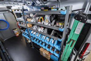 Inside of a van that has been upfitting with shelving for a plumber.
