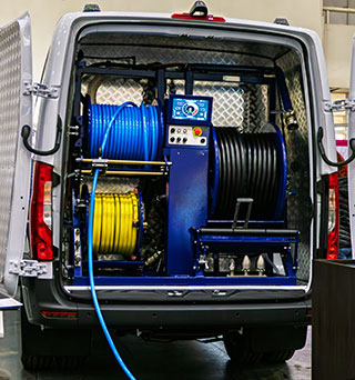 Rear view of an upfitted van with utility equipment and racks inside of it