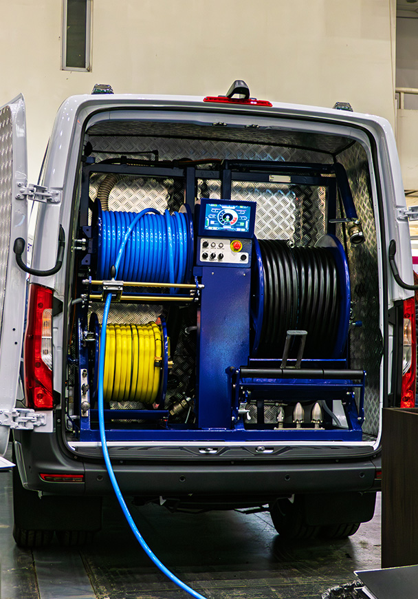 A vehicle upfitted for pest control with racks and hoses and tanks