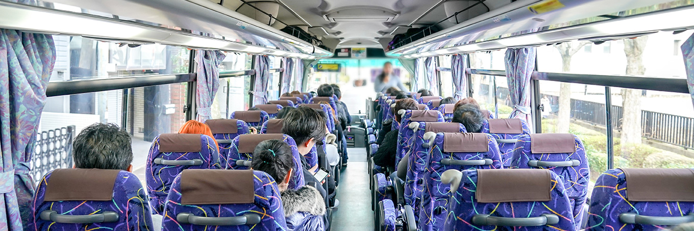 A landscape of a shuttle bus full of people from back to the front