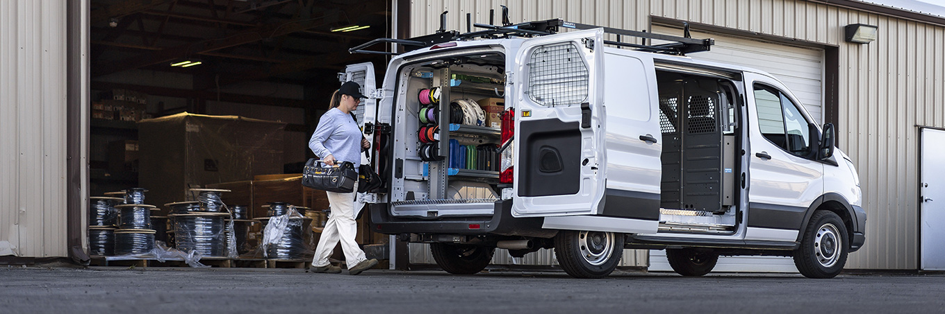 A woman walking toward an upfitting HVAC Van from Adrian Steel